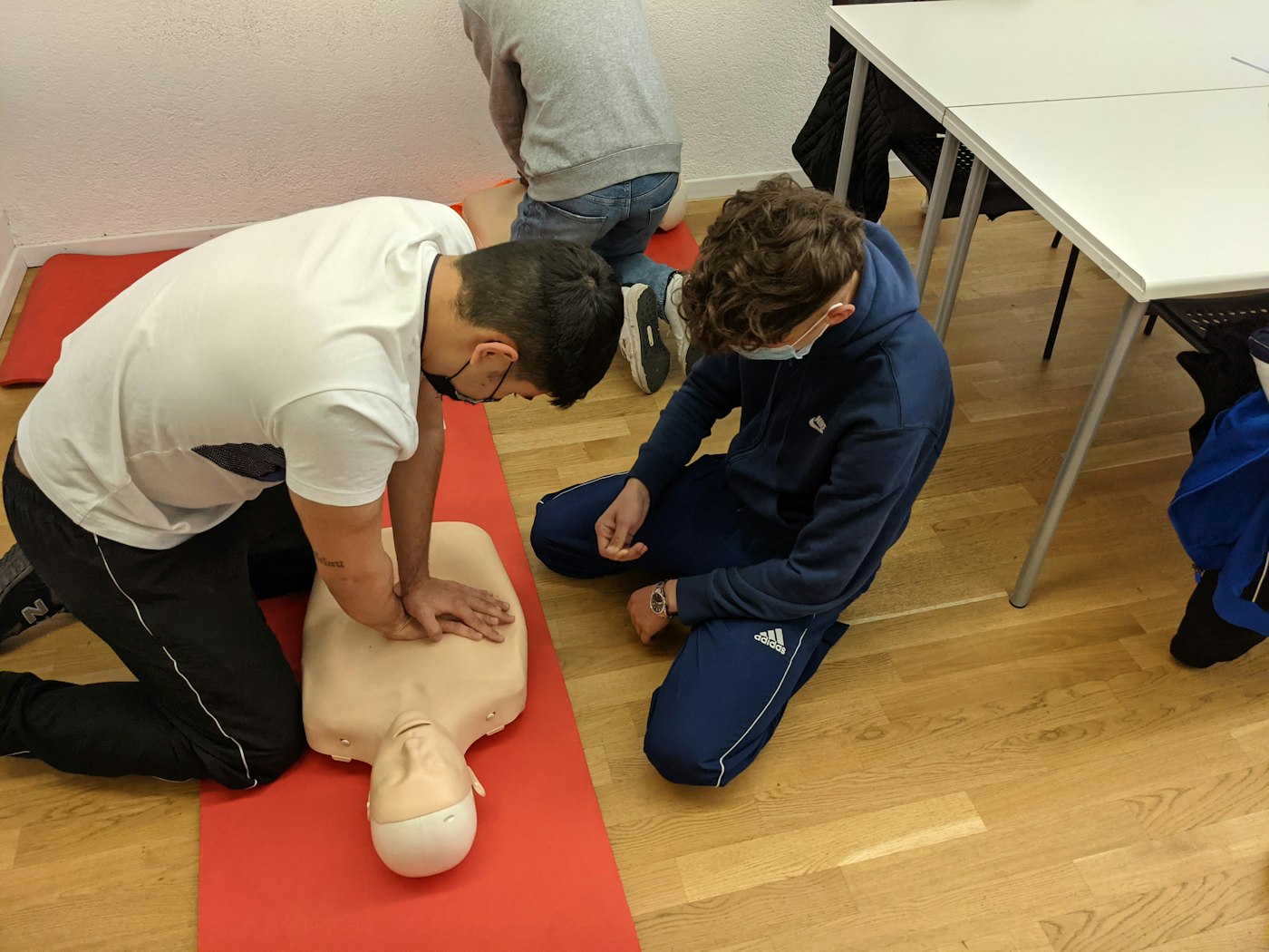 Students practicing chest compressions on manikins during a small-group Masters CPR class in Nashville