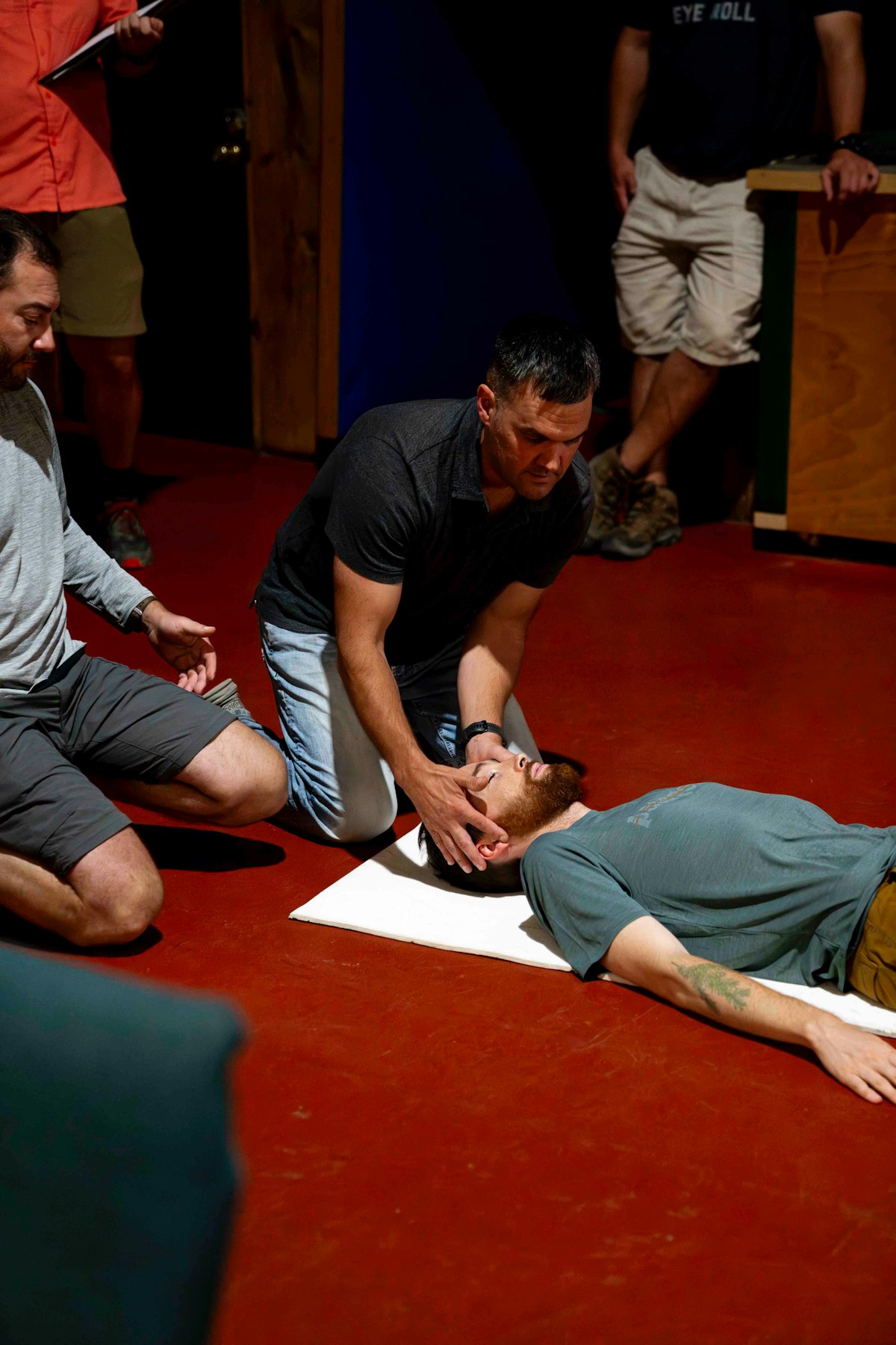 A Masters CPR instructor guiding a student through a hands-on airway and assessment check during an in-person class